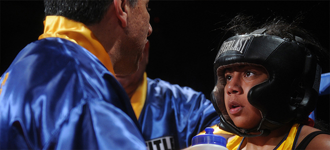 kid learning how to box from his coach